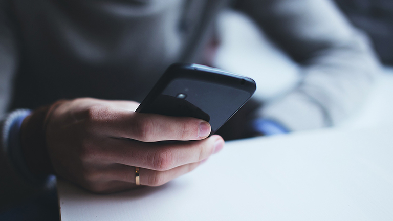 Ihmisen kädet ja kännykkä kädessä. kuvituskuva.